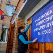A Member Of The Local Electoral Commission Hangs A Banner On The Doors Of A Polling Station Ahead Of The Planned Referendum In Donetsk